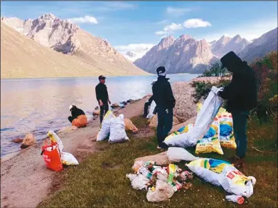  ??  ?? 為了維護自然環境美景，志願者們在景區收集垃­圾。（取材自澎湃新聞）