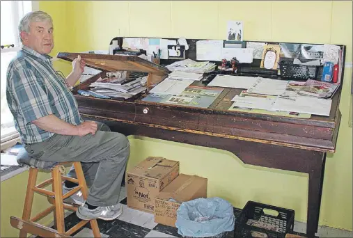  ?? SUBMITTED PHOTO ?? Fletcher Lawrence shows the storage capacity of this antique wooden desk in his office. It is well over 100 years old.