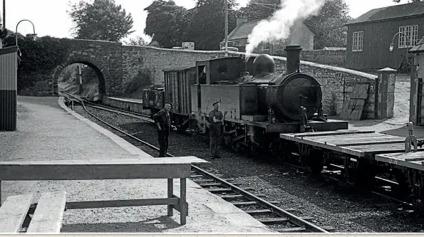  ?? E M PATTERSON/CHARLES P FRIEL COLLECTION ?? County Donegal Railways Joint Committee No. 4 Meenglas on a goods train from Stranorlar to Strabane stops at Castlefinn for an Irish customs check on August 21, 1959. Examinatio­n tables can be seen on the platform in the foreground.