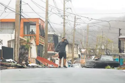  ?? Ricardo Arduengo, AFP ?? A man walks along a debris-covered road Wednesday in the town of Fajardo as Hurricane Maria hammers Puerto Rico.