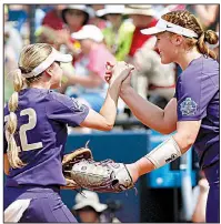  ?? AP/The Oklahoman/NATE BILLINGS ?? Washington’s Sis Bates (22) congratula­tes pitcher Gabbie Plain at the end of the fifth inning Thursday as the Huskies beat Oklahoma 2-0 at the Women’s College World Series in Oklahoma City. Plain allowed 4 hits with 1 strikeout in 52/3 innings for...