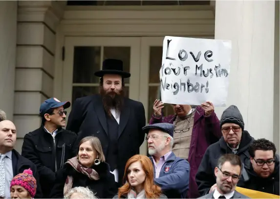  ??  ?? People opposed to Republican presidenti­al hopeful Donald Trump’s proposal to ban Muslims from entering the United States stand on the steps of New York’s City Hall during an interfaith rally in Manhattan. Inset below: Mr Trump