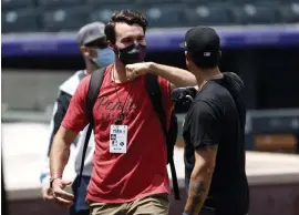  ?? David Zalubowski, The Associated Press ?? Rockies outfielder Sam Hilliard, left, greets infielder Josh Fuentes while walking into Coors Field to take part in baseball drills on Monday.