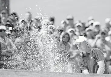  ?? Charlie Riedel / Associated Press ?? First-round leader Jordan Spieth blasts out of a bunker on the seventh hole during the second round at the Masters on Friday. He overcame a double bogey on the opening hole to post a 74 and a tie for fourth place.