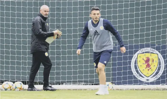  ??  ?? 0 Steve Clarke runs the rule over midfielder and man of the moment John Mcginn at the Oriam as the manager oversees his first Scotland training session.
