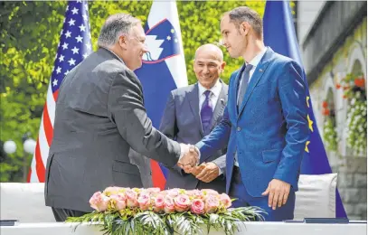  ?? Jure Makovec The Associated Press ?? Secretary of State Mike Pompeo and Foreign Minister Anze Logar shake hands Thursday as Prime Minister Janez Jansa looks on Thursday in Bled, Slovenia. Pompeo signed a joint declaratio­n on 5G technology security.