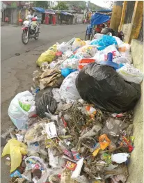  ?? SUNSTAR FILE ?? FOOD FOR TRASH.
Proper disposal of garbage means free cans of sardines in some parts of Cebu City.