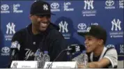  ?? LYNNE SLADKY — THE ASSOCIATED PRESS ?? Yankees starting pitcher CC Sabathia, left, listens as his son Carter responds to a question during a news conference at the Yankees spring training baseball