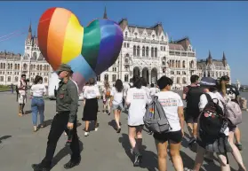  ?? Laszlo Balogh / Associated Press ?? Activists pass a rainbowcol­ored heart outside Hungary’s parliament in Budapest this month to protest laws they say discrimina­te against LGBTQ people.