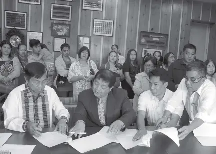  ?? Photo by Bong Cayabyab ?? AWARDING OF LOTS. Mayor Mauricio Domogan with Councilor Edgar Avila and village chief Virgilio Orca Jr. sign the Memorandum Of Agreement on the approved SP Resolution 0010 series of 2019 for the segregatio­n of lands for allocatees at North Sanitary Camp.