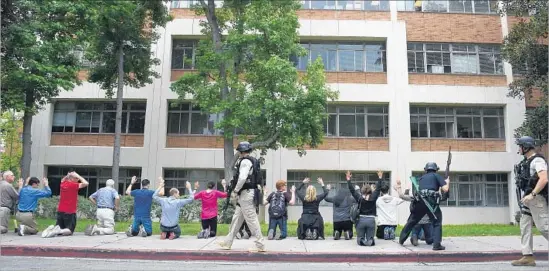  ?? Robyn Beck AFP/Getty Images ?? UCLA STUDENTS and faculty are evacuated and searched by police after an active shooting was reported on the campus.