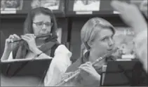  ?? PETER LEE, RECORD STAFF ?? Laurel Swinden, left, and Kirsten MacLean, far right, play their instrument­s at the library.