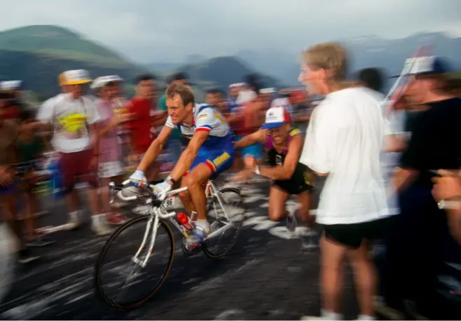  ??  ?? Thierry Marie receives a helping hand from a fan on Alpe d’Huez, 91 Tour