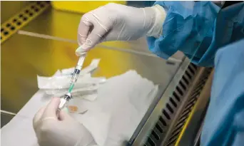  ??  ?? A person holds an experiment­al vaccine against the AIDS virus. — AFP