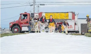  ?? ALISON JENKINS/LOCAL JOURNALISM INITIATIVE REPORTER ?? Junior firefighte­rs, from left, Madison Jessome, Macelynn Dwyer, Amanda Kingman and Anna Jesulaitis sprint to a refreshing finish after a Thursday night training session at the BordenCarl­eton fire department.