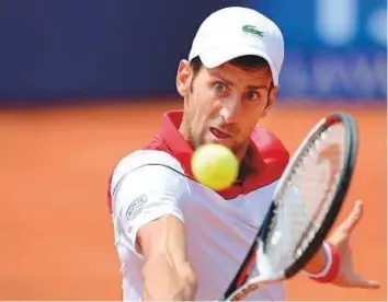  ?? AFP ?? Serbia’s Novak Djokovic hits a backhand return to Slovakia’s Martin Klizan during their Barcelona Open ATP tournament match yesterday. The Serb lost 6-2, 1-6, 6-3.