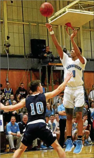  ?? TANIA BARRICKLO — DAILY FREEMAN ?? Saugerties eighth-grader Dior Johnson scores 1,000th point on a 3-point field goal, as Pine Plains’ Matt Beam defends on Tuesday.