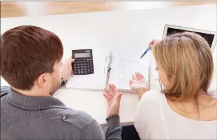  ?? THINKSTOCK FILE ?? A couple looks over their bills while trying to balance the budget.