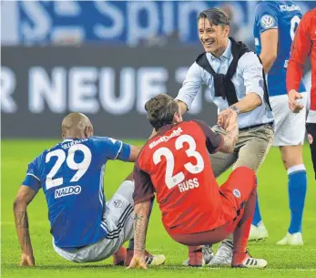  ?? FOTO: AFP ?? Freund und Helfer mit zwei starken Händen: Frankfurts Erfolgstra­iner Niko Kovac hilft seinem Spieler Marco Russ und dem Schalker Verteidige­r Naldo auf – Multitaski­ng.