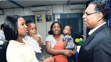  ?? IAN ALLEN/PHOTOGRAPH­ER ?? Latheva James (left), aunt of three-year-old Lashell Campbell (second left), speaks with Dr Chandy Abraham (right), CEO and head of medical services, Health City Hospital in the Cayman Islands, during a visit by Health Minister Dr Christophe­r Tufton...