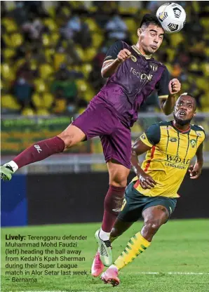  ?? — Bernama ?? Lively: Terengganu defender Muhammad Mohd Faudzi (letf) heading the ball away from Kedah’s Kpah Sherman during their Super League match in Alor Setar last week.