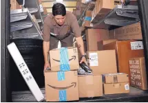  ?? LYNNE SLADKY/ASSOCIATED PRESS ?? UPS employee Liz Perez unloads packages for delivery in Miami. Amazon’s biggest shopping days of the year are coming up Monday and Tuesday.