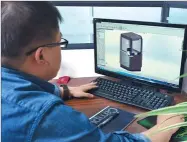  ??  ?? A designer with Maglayer in Weifang works on a 3-D printer.