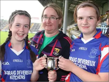  ??  ?? Joint captains Ciara McMahon and Amy O’Connor receive the cup from Aine Kennedy.