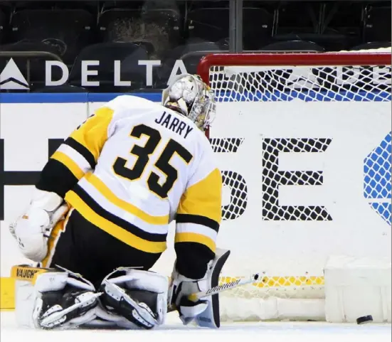  ?? Bruce Bennett/Getty Images ?? Tristan Jarry eyes one of four Rangers goals he surrendere­d in the first period Tuesday night in New York.