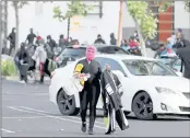  ?? ANDA CHU — STAFF PHOTOGRAPH­ER ?? A looter walks through the Bayfair Center parking lot in San Leandro in May 2020after a group people ransacked shops.