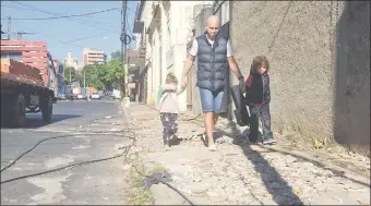  ??  ?? Un hombre y sus hijas transitan por una vereda desastrosa y con cables sueltos de la calle Nuestra Señora de la Asunción y Piribebuy.