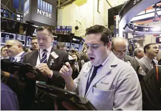  ??  ?? NEW YORK: Stock traders work at the New York Stock Exchange on Thursday. Stocks are opening slightly higher following two days of losses as investors respond to some positive earnings surprises. —AP