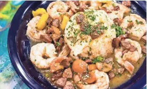  ??  ?? This is a shrimp and grits dish features jumbo Gulf shrimp, slow-cooked andouille sausage and smoked plum tomatoes over classic stone ground cheese grits.