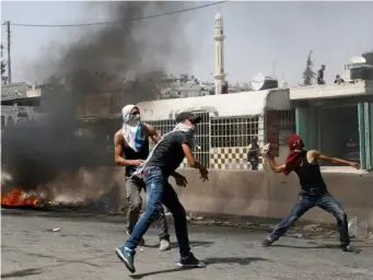  ?? (Reuters) ?? Palestinia­n protesters hurl stones towards Israeli troops during the violence