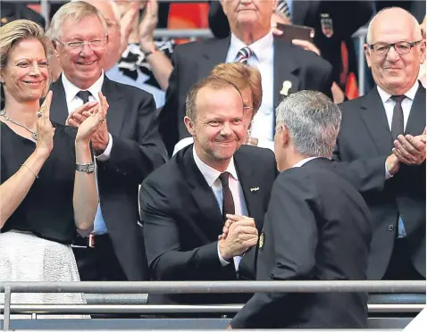  ??  ?? ■
Sir Alex Ferguson looks on as United’s executive vice-chairman Ed Woodward congratula­tes Jose Mourinho on his side’s Community Shield success over Leicester City last weekend.