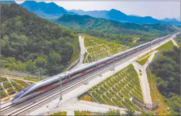  ?? Photo taken on July 10, 2021 ?? A Fuxing intelligen­t bullet train running on a high-speed railway connecting Beijing and Harbin, capital of northeast China's Heilongjia­ng province.