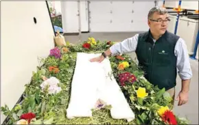  ?? AFP ?? Return Home CEO Micah Truman shows a demonstrat­ion ‘vessel’ for the deceased, decorated with flowers and compostabl­e mementos on top of a bed of straw in Auburn, Washington on March 14.