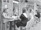  ??  ?? From left, Georgia Santino, Claire Tzagournis, Claudia Santino and others eat on the patio at Ethyl and Tank near Ohio State. Georgia Santino attends Columbus State, and her sister Claudia goes to Oregon University; Tzagournis attends Miami University of Ohio.