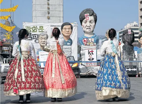  ?? REUTERS ?? Tourists wearing traditiona­l costume ‘hanbok’ take pictures of a statue depicting South Korea’s ousted leader Park Geun-hye in Seoul, South Korea, yesterday.