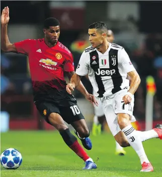  ?? DAVE THOMPSON/THE ASSOCIATED PRESS ?? Manchester United’s Marcus Rashford, left, is caught flat-footed by charging Juventus star Cristiano Ronaldo during Champions League action at Old Trafford on Tuesday. Juventus won 1-0.