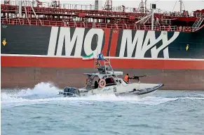  ?? AP ?? An Iranian Revolution­ary Guard gunboat guards the British-flagged oil tanker Stena Impero, which was seized in the Strait of Hormuz last month. Iran and Russia are to hold joint naval exercises around the strait.