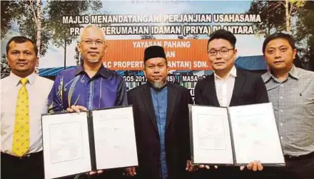  ?? PIC BY FARIZUL HAFIZ AWANG ?? Yayasan Pahang general manager Datuk Mahmud Mohd Nawawi (second from left) with O&C Resources Bhd managing director Billy Ong Kah Hoe (second from right) at the PRIYA Scheme signing ceremony yesterday.