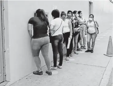  ??  ?? Las personas formando fila en Tecopesca para entregar sus solicitude­s de trabajo.