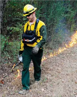  ?? AP PHOTO/JAY REEVES ?? Brad Lang, a firefighte­r with the Alabama Forestry Commission, sets a backfire to help extinguish a wildfire near Brookside, Ala., on Thursday. Wildfires have burned hundreds of acres a day in the South as a drought worsens across much of the region.