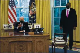  ?? EVAN VUCCI — THE ASSOCIATED PRESS ?? Secretary of Defense Lloyd Austin listens as President Joe Biden speaks before signing an Executive Order in the Oval Office on Monday.