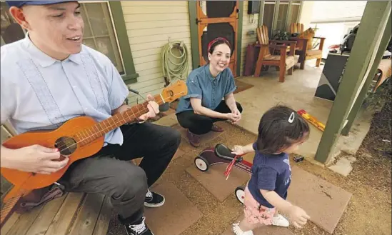  ?? Genaro Molina Los Angeles Times ?? LAS CAFETERAS members and couple David Flores and Leah Rose Gallegos watch over daughter Ella. Gallegos aims for more family-oriented classes at her studio.