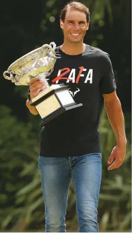  ?? — AP ?? Newly-cowned Australian Open champion Rafael Nadal of Spain poses for a photo with his trophy at Government House in Melbourne on Monday.