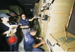  ?? (Keith Bacongco) ?? FAKE CIGARETTE BRANDS – Agents of the Criminal Investigat­ion and Detection Group in Davao open boxes containing cigarettes with fake brands during a search of a warehouse owned by a Chinese national in Davao City Wednesday.