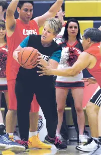  ?? CLYDE MUELLER/THE NEW MEXICAN ?? Sen. Howie Morales, D-Silver City, left, and Sen. Benny Shendo Jr., D-Bernalillo, defend against Rep. Gail Armstrong, R-Socorro, as she tries to pass the ball Wednesday during the legislator­s’ annual Hoops 4 Hope game at Santa Fe High’s Toby Roybal...