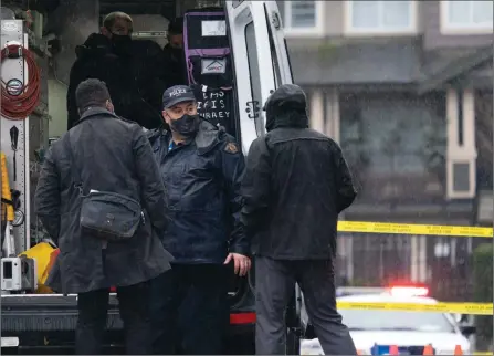  ?? The Canadian Press ?? Police look over a fatal shooting scene in Surrey on Feb. 4. The federal government announced Tuesday it was allowing cities to issue handgun bans, a move the City of Vancouver said it would undertake.